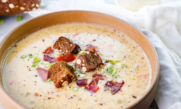 Beer Cheese Soup with Crispy Bacon, Green Onions, and Dark Rye Croutons